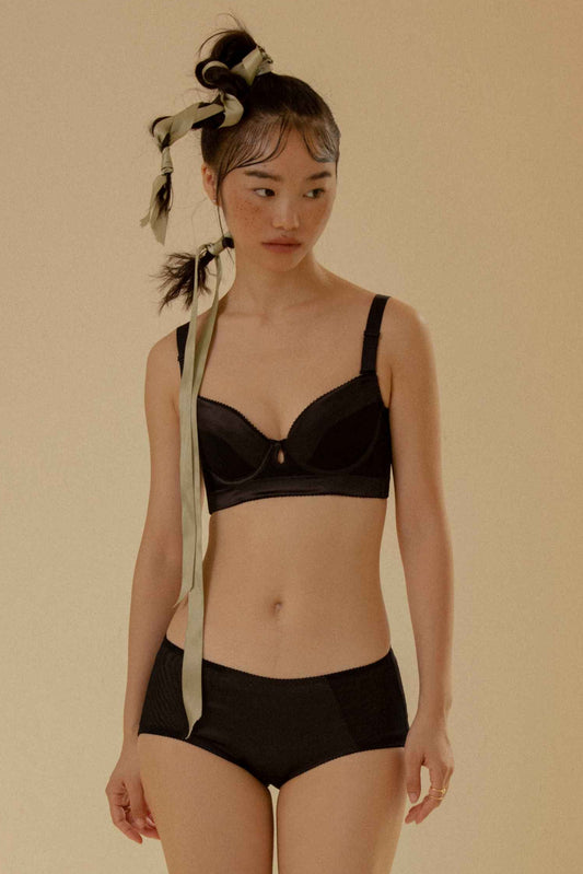 黑色光面機能調整型內衣,透過高側收與穩定支撐,修飾副乳與外擴,塑造自然平滑的胸型線條。